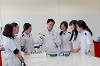 Tiến sĩ, Bác sĩ thú y Đinh Xuân Phát hướng dẫn sinh viên trong thao tác sinh học phân tử. Ảnh: NVCC