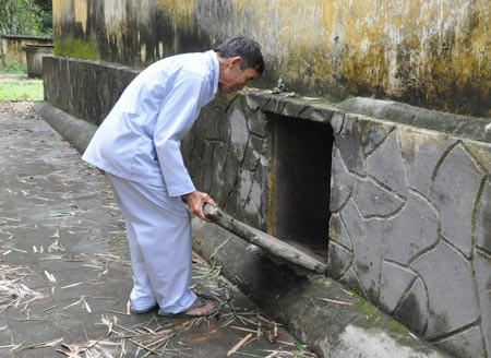 Ông Lê Khắc Phiến bên miệng hầm vào kho lương thực và trạm y tế tiền phương dưới nền đình Thạch Tân.