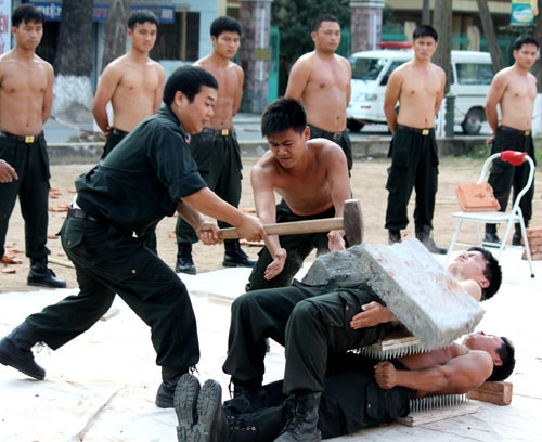 Người chịu cú phá bê tông trên bụng, người chịu sức nặng của đồng đội nằm trên cùng 2 bàn chông kẹp lấy thân trần. Người chịu cú phá bê tông trên bụng, người chịu sức nặng của đồng đội nằm trên cùng 2 bàn chông kẹp lấy thân trần.