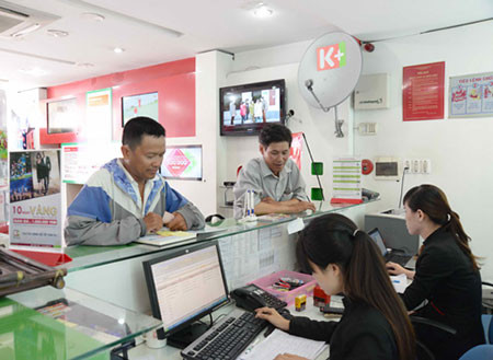 Cạnh tranh sẽ tạo cú hích về giá và chất lượng cho dịch vụ (trong ảnh: Khách đang đăng ký dịch vụ truyền hình K+) - Ảnh: D.Đ.M