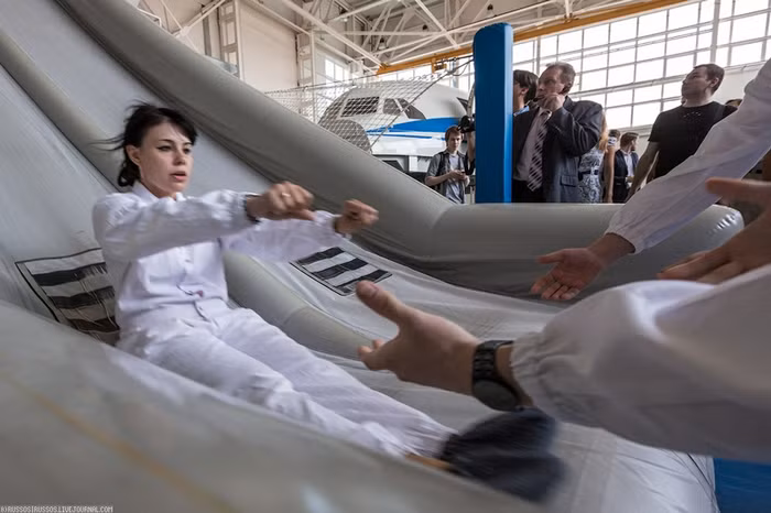 Hướng dẫn khách đi tàu bay trượt ra khỏi cửa thoát hiểm