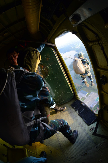 Còi lệnh đã báo, các học viên lần lượt nhảy khỏi cửa máy bay vào khoảng không, dưới sự kiểm soát của huấn luyện viên. Trước bụng học viên là dù phụ để đảm bảo an toàn khi có trục trặc với dù chính.