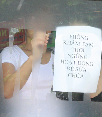 Nhân viên phòng khám Maria dán bảng thông báo "ngưng hoạt động để sửa chữa", một ngày sau cái chết của bệnh nhân Phong. Ảnh: Phan Dương. Nhân viên phòng khám Maria dán bảng thông báo "ngưng hoạt động để sửa chữa", một ngày sau cái chết của bệnh nhân Phong. Ảnh: Phan Dương.