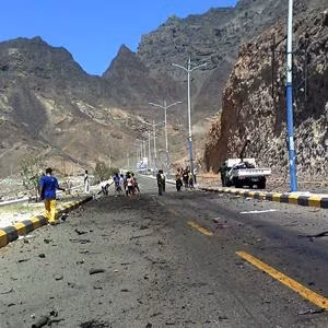 Những người Yemen quan sát nơi xảy ra vụ tấn công tự sát nhắm vào đoàn xe của Bộ trưởng Quốc phòng