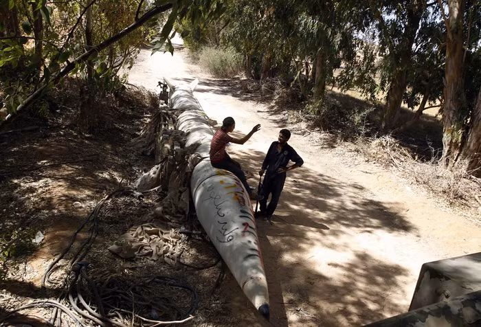 Một phiến quân thuộc phe nổi dậy đang nói chuyện với đồng đội của mình ngay cạnh một quả tên lửa Scud do Liên Xô sản xuất gần làng Sirte, một trong những vị trí trọng yếu của quân đội trung thành với đại tá Gaddafi (ảnh chụp ngày 21/9/2011). Một phiến quân thuộc phe nổi dậy đang nói chuyện với đồng đội của mình ngay cạnh một quả tên lửa Scud do Liên Xô sản xuất gần làng Sirte, một trong những vị trí trọng yếu của quân đội trung thành với đại tá Gaddafi (ảnh chụp ngày 21/9/2011).