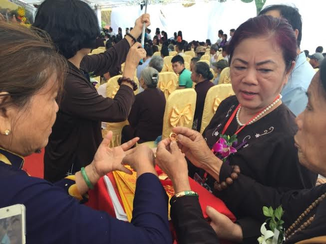 Các phật tử công đức vào tượng phật với hy vọng những khổ đau, hệ lụy sẽ tan biến. Ảnh: Quỳnh An.