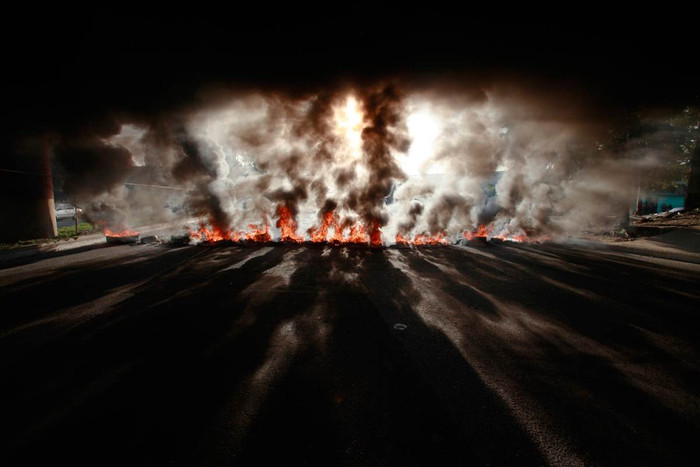 Khói, lửa bốc lên từ những chiếc lốp xe bị người biểu tình đốt cháy ở thành phố Guatemala, Guatemala ngày 24/10/2011.