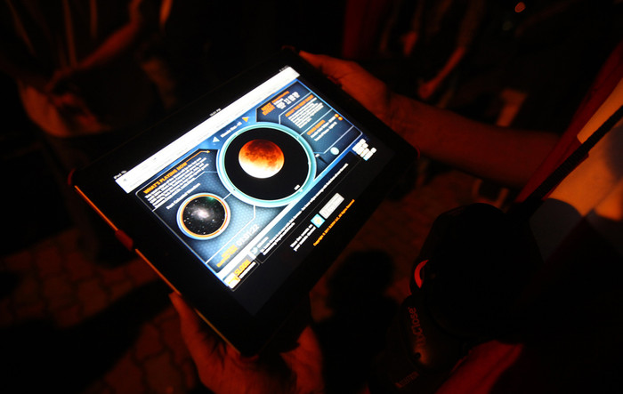 Một người đàn ông sử dụng chiếc máy tính bảng để xem hiện tượng nguyệt thực toàn phần trong khi nó đang xảy ra trên bầu trời thành phố Kuala Lumpur, Malaysia, 10/12/2011. Một người đàn ông sử dụng chiếc máy tính bảng để xem hiện tượng nguyệt thực toàn phần trong khi nó đang xảy ra trên bầu trời thành phố Kuala Lumpur, Malaysia, 10/12/2011.