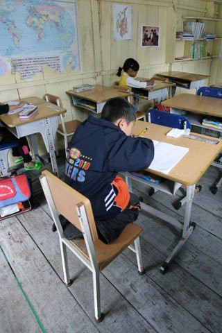 Một tư thế ngồi viết lạ tại điểm trường Cửa Vạn do bàn ghế không đúng kích cỡ. Một tư thế ngồi viết lạ tại điểm trường Cửa Vạn do bàn ghế không đúng kích cỡ.