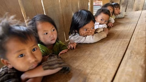 Dưới thì chân không chạm đất, phía trên thì mặt bàn cao ngang cổ nên các em phải dướn hết người mới có thể khoanh tay trên mặt bàn.