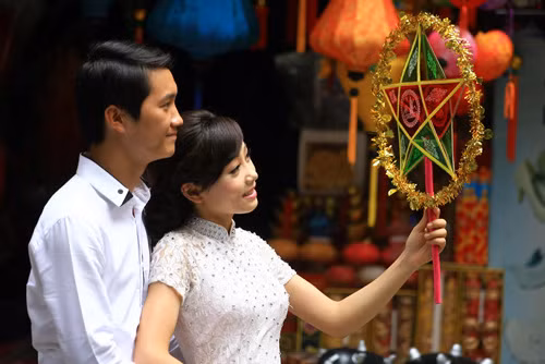 Một đôi cưới đi chụp ảnh tạo dáng bên đèn ông sao.