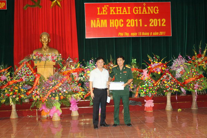 Thay mặt Trường Quốc tế Việt Anh và Hệ thống Lập trình viên Quốc tế BachKhoa-Aptech, Nhà báo Nguyễn Tiến Bình đã trao tặng tới Đại tá Trần Văn Chính - Phó Hiệu trưởng 10 suất học bổng toàn phần tiếng Anh trị giá 3.000.000 đ/suất và 5 suất học bổng tin học ngắn hạn trị giá 100 USD/suất