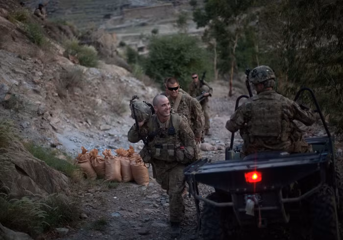 Trung sĩ Matt Murray, 25 tuổi, nở nụ cười chào trung úy thứ hai Andrew Ferrara trong khi leo lên một vị trí quan sát ở trên cao, tại tiền đồn Monti, tỉnh Kunar, 12/09/2011.