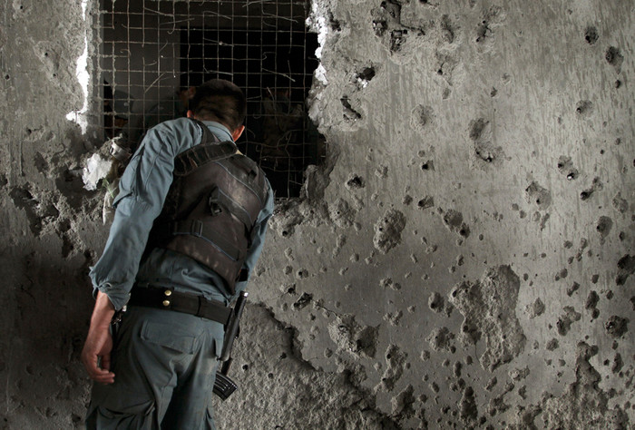 Một cảnh sát Afghanistan quan sát các thi thể của phiến quân trong ngôi nhà mà chúng đã chiếm đóng để tấn công sứ quán Mỹ ở Kabul. Một cảnh sát Afghanistan quan sát các thi thể của phiến quân trong ngôi nhà mà chúng đã chiếm đóng để tấn công sứ quán Mỹ ở Kabul.