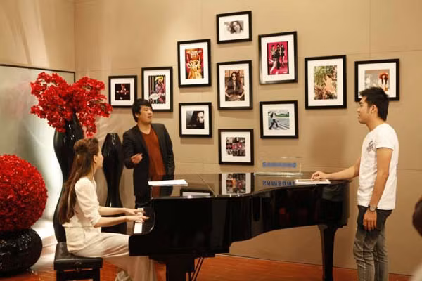 Thanh Bùi đang "thị phạm" cho thí sinh còn Hồ Hà đệm đàn cho họ hát.