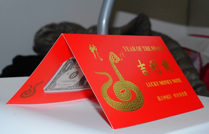 Đồng 1 USD được đặt trong 1 phong bì gấp màu đỏ, có mạ chữ vàng. Theo quan niệm của người phương Đông, màu đỏ và màu vàng tượng trưng cho sự may mắn và tài lộc. Đồng 1 USD được đặt trong 1 phong bì gấp màu đỏ, có mạ chữ vàng. Theo quan niệm của người phương Đông, màu đỏ và màu vàng tượng trưng cho sự may mắn và tài lộc.