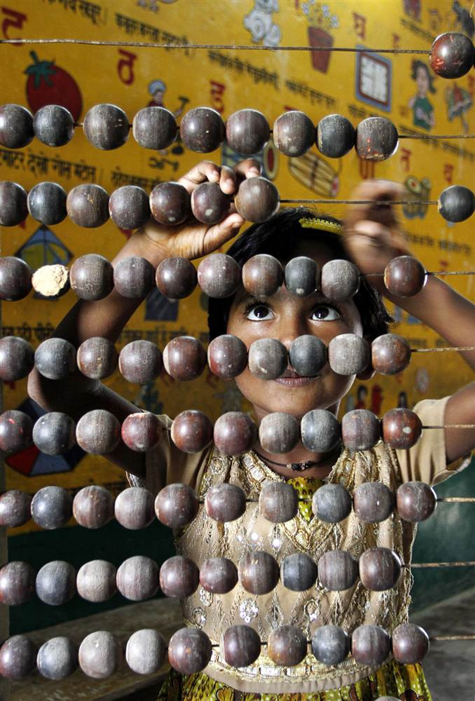 Một học sinh tiểu học ở Allahabad, Ấn Độ đang thực hiện phép toán trên chiếc bàn tính treo nhân Ngày tri thức quốc tế (ảnh chụp ngày 7/9/2011). Một học sinh tiểu học ở Allahabad, Ấn Độ đang thực hiện phép toán trên chiếc bàn tính treo nhân Ngày tri thức quốc tế (ảnh chụp ngày 7/9/2011).