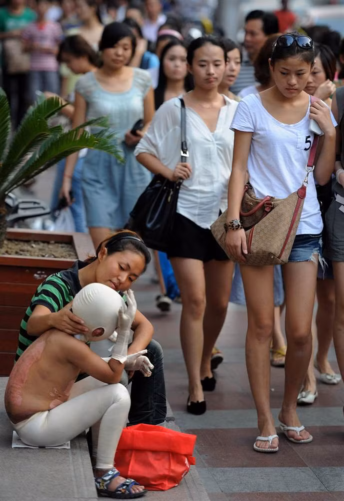 Hai mẹ con người Trung Quốc đang xin bố thí trên một con phố ở Hợp Phì. Con trai của người phụ nữ bị bỏng nặng trong một trận hoả hoạn cách đây 3 tháng (ảnh chụp ngày 4/9/2011). Hai mẹ con người Trung Quốc đang xin bố thí trên một con phố ở Hợp Phì. Con trai của người phụ nữ bị bỏng nặng trong một trận hoả hoạn cách đây 3 tháng (ảnh chụp ngày 4/9/2011).