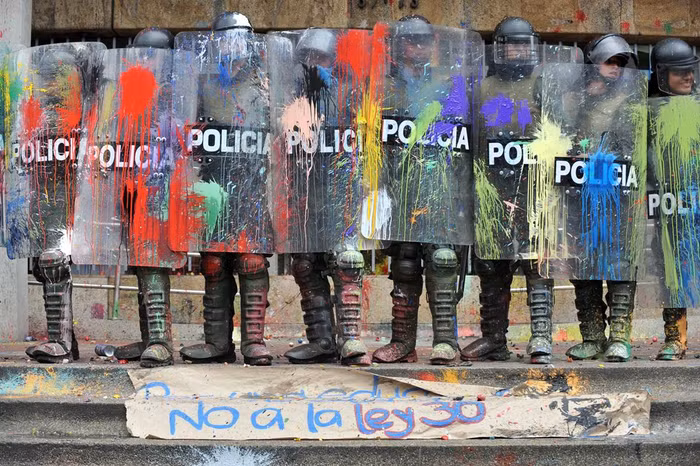 Cảnh sát chống bạo động đứng dàn hàng ngang, hứng chịu những quả bóng nước đầy màu sặc sỡ từ các giáo viên và sinh viên biểu tình tại Bogota, Colombia đang đấu tranh bảo vệ, yêu cầu chính quyền tiếp tục coi trọng sự nghiệp giáo dục công cộng ngày 7/92011. Cảnh sát chống bạo động đứng dàn hàng ngang, hứng chịu những quả bóng nước đầy màu sặc sỡ từ các giáo viên và sinh viên biểu tình tại Bogota, Colombia đang đấu tranh bảo vệ, yêu cầu chính quyền tiếp tục coi trọng sự nghiệp giáo dục công cộng ngày 7/92011.