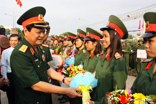 Tại đây, các đồng chí đã động viên thăm hỏi và tặng quà các chiến sĩ mới. Trong phần quà tặng có hai quyển sách: Hoàng Sa, Trường Sa là của Việt Nam và Biển Đông yêu dấu do Nhà xuất Trẻ phát hành. Đặc biệt, trong số các bạn trẻ trúng tuyển nghĩa vụ quân sự đợt này, có 10 tân binh là các nữ thanh niên của các huyện Bình Chánh, quận Tân Bình, quận Gò Vấp, quận 5, 9 và 12. ẢNH: Thượng tướng Nguyễn Thành Cung, Thứ trưởng Bộ quốc phòng, tặng hoa cho 10 nữ tân binh của TP Hồ Chí Minh.