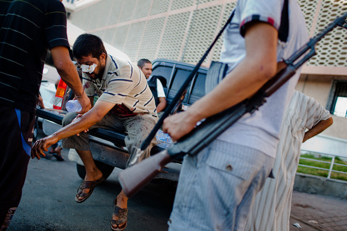 14. Một binh sỹ của phe nổi dậy bị thương đang ngồi sau chiếc xe bán tải. 14. Một binh sỹ của phe nổi dậy bị thương đang ngồi sau chiếc xe bán tải.