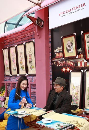 Hoa khôi sinh viên Việt Nam Đặng Mỹ Huyền được trải nghiệm viết thư pháp với sự hướng dẫn của thư pháp gia Trần Quốc Chí.