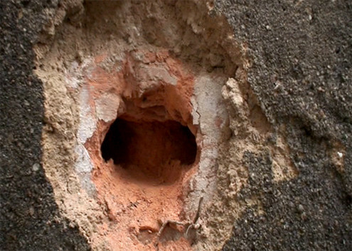 Sau vụ nổ xe máy ở Bắc Ninh, bức tường xuất hiện những vết thủng lớn. Ảnh: Bá Đô.