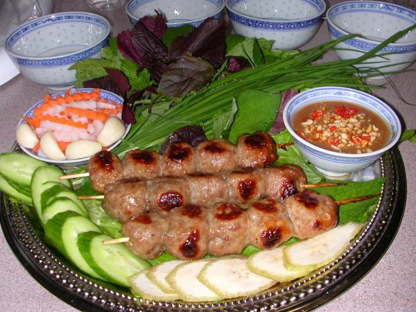 2. Nem Ninh Hòa. Nem nướng Ninh Hòa được làm từ nguyên liệu thịt đùi heo còn nóng hôi hổi khi vừa xẻ thịt xong. Thịt được giã nhuyễn bằng máy và giã sơ lại bằng chày tay rồi ướp gia vị. Hỗn hợp thịt này được quấn quanh chiếc đũa nướng trên than hồng. Mùi thơm lừng tỏa ra nhờ các gia vị và hương liệu. Khi nem chín vàng, đầu bếp cắt thành nhiều miếng nhỏ và dài cho dễ gói. 2. Nem Ninh Hòa. Nem nướng Ninh Hòa được làm từ nguyên liệu thịt đùi heo còn nóng hôi hổi khi vừa xẻ thịt xong. Thịt được giã nhuyễn bằng máy và giã sơ lại bằng chày tay rồi ướp gia vị. Hỗn hợp thịt này được quấn quanh chiếc đũa nướng trên than hồng. Mùi thơm lừng tỏa ra nhờ các gia vị và hương liệu. Khi nem chín vàng, đầu bếp cắt thành nhiều miếng nhỏ và dài cho dễ gói.