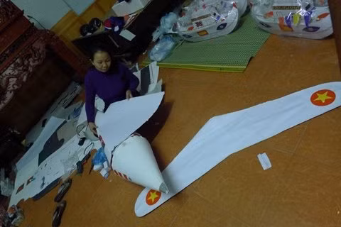 Người phụ nữ lớn tuổi đang ngồi làm chiếc máy bay hình dáng giống chiếc máy bay dân dụng để bán. Bà tâm sự: “Trong làng ngày này ai cũng làm đồ mã cả. Nhà tôi cũng có nghề làm tranh Đông Hồ, nhưng ngày nay bán không được. Tất cả vì mưu sinh nên phải quay sang làm đồ mã thôi".