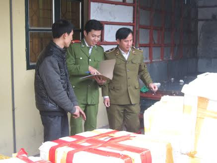 Lái xe Đỗ Văn Sơn (áo đen bên trái) khai báo với cơ quan chức năng về lô hàng.