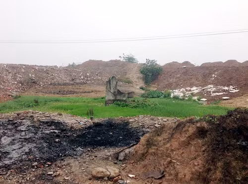 Một ngôi mộ có nguy cơ bị san lấp giữa một khối đất khổng lồ tại một dự án đang triển khai giải toản mặt bằng.