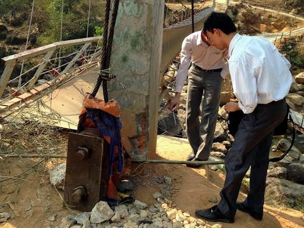 Lực lượng chức năng Lai Châu kiểm tra, xác minh việc ốp gạch vào trụ cầu. (Ảnh: Công Hải/Vietnam+)