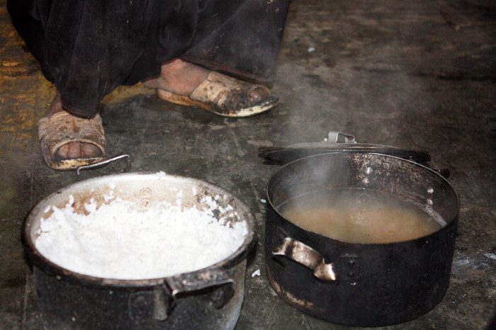 Đôi chân lấm lem bùn đất với nồi thức ăn lõng bõng nước Đôi chân lấm lem bùn đất với nồi thức ăn lõng bõng nước