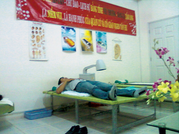 Bệnh nhân thoái hóa cột sống được nằm thử giường mátxa và đeo đai laser.