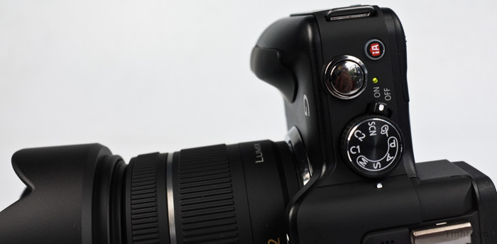 Cận cảnh đỉnh máy, từ trái sang phải ta có loa, nút gạt mở flash, chân đèn, micro trái phải, cụm phím chinh chế độ kiêm công tắc nguồn, nút chụp và nút kích hoạt chế độ thông minh