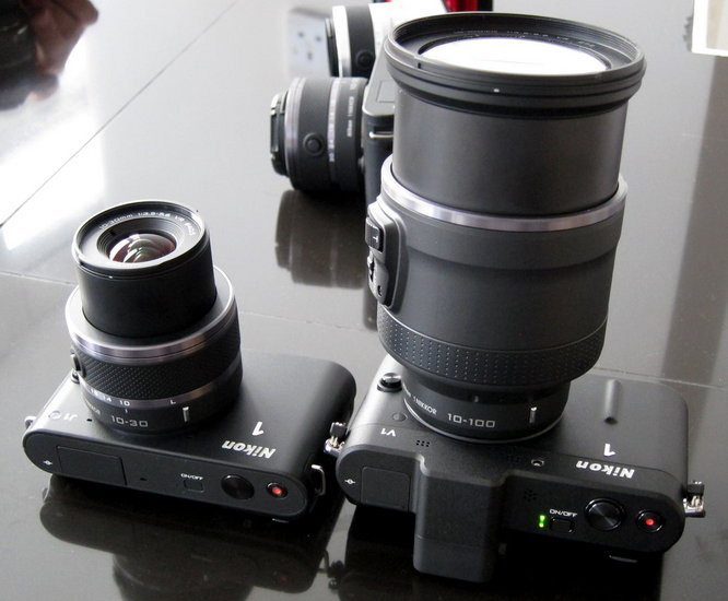 Nikon J1 và V1 Nikon quyết định những chiếc máy ảnh không gương lật của họ phải có tốc độ nhanh hơn của các hãng khác. Và kết quả là hai chiếc máy J1 và V1 trang bị cảm biến ảnh 10,1-megapixel có thể chụp với 73 điểm bắt nét nhanh và khả năng quay phim HD 1080p. J1 và V1 khác nhau ở điểm J1 có đèn flash nhưng không có ống ngắm điện tử còn V1 thì có ống ngắm điện tử và cổng cắm thêm thiết bị phụ nhưng lại không có flash. Giá: J1 - 13,5 triệu đồng (650 USD); V1 - 18,7 triệu đồng (900 USD) Nikon J1 và V1 Nikon quyết định những chiếc máy ảnh không gương lật của họ phải có tốc độ nhanh hơn của các hãng khác. Và kết quả là hai chiếc máy J1 và V1 trang bị cảm biến ảnh 10,1-megapixel có thể chụp với 73 điểm bắt nét nhanh và khả năng quay phim HD 1080p. J1 và V1 khác nhau ở điểm J1 có đèn flash nhưng không có ống ngắm điện tử còn V1 thì có ống ngắm điện tử và cổng cắm thêm thiết bị phụ nhưng lại không có flash. Giá: J1 - 13,5 triệu đồng (650 USD); V1 - 18,7 triệu đồng (900 USD)