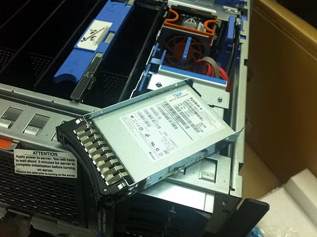 Với con máy này lần đầu tiên mình chứng kiến ổ cứng SSD dùng cho máy chủ, trong ảnh là ảnh thực tế của ổ cứng IBM 50 GB 2.5in Slim-HS SATA SSD, ổ cứng này chỉ mỏng bằng một nửa ổ cứng SAS(trong hình là ổ cứng SSD sử dụng khay của ổ cứng SAS) Với các doanh nghiệp sử dụng hệ thống máy chủ x3850x5 và x3950x5 thì thường họ mua kèm Hệ thống lưu trữ riêng (thường gọi là họ lưu trữ SAN), các ổ cứng gắn trực tiếp trên máy chỉ lưu trữ các chương trình để xử lý, còn dữ liệu thường được lưu sang hệ thống SAN, DS,…gọi là lưu trữ ngoài (external Storage); Dòng máy trước của x3850x5/x3950x5 là dòng máy x3850M2 và x3950M2 thậm chí chỉ cho phép cắm trong 04 ổ cứng 2,5” SAS, muốn lưu thêm thì xin mời dùng lưu trữ ngoài.