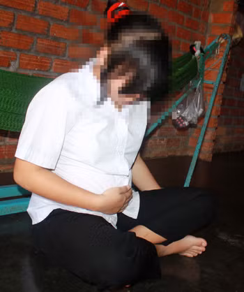 Bé Nga ứa nước mắt khi nhìn bụng đang lùm lùm lớn. Ảnh: Chế Bắc.