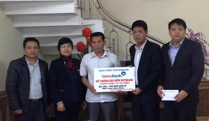 Đại diện VBI trao 100 triệu đồng tiền bảo hiểm cho gia đình khách hàng.