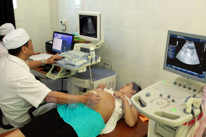 Nhân viên y tế kiểm tra sức khỏe cho một thai phụ. (Ảnh: TTXVN/Vietnam+). Nhân viên y tế kiểm tra sức khỏe cho một thai phụ. (Ảnh: TTXVN/Vietnam+).