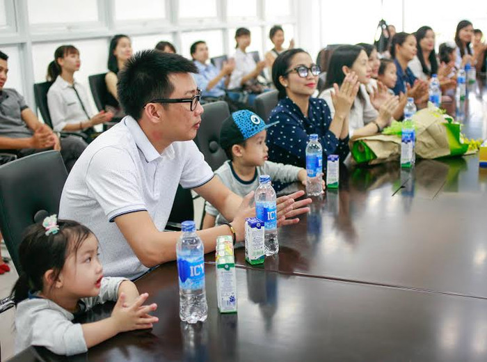 Hai bé lắng nghe chú Giám đốc giới thiệu về những cái “nhất” của siêu nhà máy sữa Vinamilk.