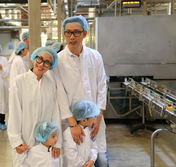 Hai bé mê mẩn trước dây chuyền đóng gói sản phẩm tự động.