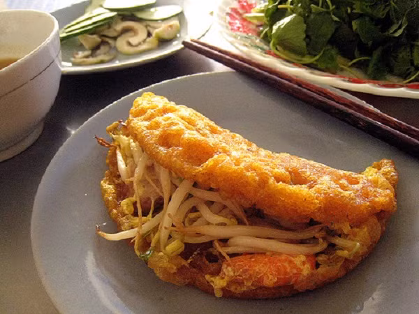 3. Bánh khoái (Huế) Đúng như tên gọi của loại bánh này, ăn bánh khoái chắc chắn bạn sẽ thấy rất thú vị. Trước tiên, bột gạo sẽ được khuấy trong nước lạnh, pha thêm một chút muối và đường thắng để bánh có màu bắt mắt. Ảnh: dmz.com