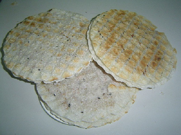 Kẹo cu đơ có bánh tráng nướng giòn ở hai mặt, ở giữa là nhân lạc rang được phủ ông một lớp mật có màu vàng hấp dẫn và bắt mắt.