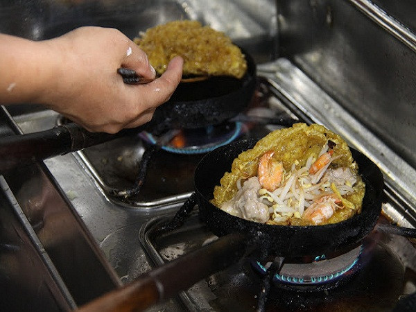 Đặt khuôn bánh lên lò, đợi nóng khuôn rồi tráng dầu cho sôi rồi mới múc bộ đổ vào. Sau đó, giải nhân lên bánh, đậy nắp chờ bánh chính cho thêm giá sống vào giữa rồi tráng lòng đỏ lên mặt bánh. Dùng vỉ gập bánh làm đôi, lật mặt bánh cho đều để bánh chín giòn mới cho ra đĩa.