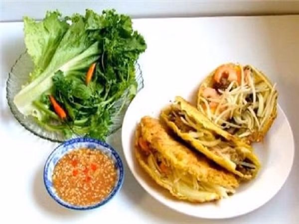 Ăn kèm với bánh là khế, đu đủ cà rốt ngâm giấm chua ngọt, cải con, xà lách, rau thơm, ngò rí và ớt. Tất cả tạo nên một món ăn đầy màu sắc hòa quyện nhiều hương vị, chua, chát, béo bì.