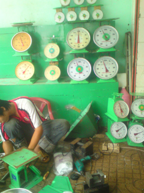 Nhân viên đang "phù phép" cho cân tại chợ Kim Biên Nhân viên đang "phù phép" cho cân tại chợ Kim Biên