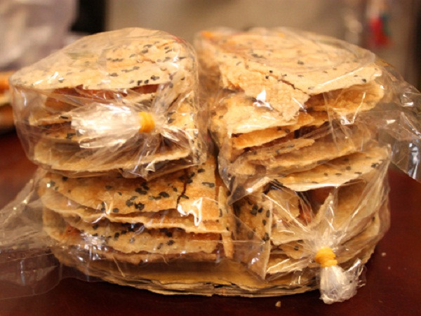 1. Bánh cu đơ (Hà Tĩnh) Câu chuyện về nguồn gốc của loại bánh này được tương truyền như sau: Đám cưới con trai đầu lòng, người cha nghèo không có gì để làm lễ mời bà con hàng xóm khi trong nhà chỉ còn mỗi mật đường mía và lạc sống. Người cha đã nghĩ ra món kẹo bằng cách rang chín lạc rồi trộn mật đổ lên trên. Món ăn này được gọi là Cu Hai. Sau đó, người Pháp đến Việt Nam gọi món này là Cu Đơ (Duex có nghĩa là hai). Nguồn ảnh: Ngoisao.net