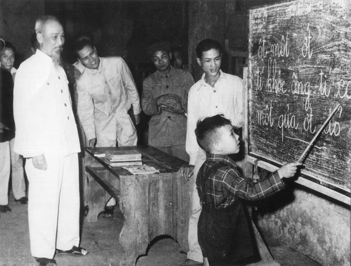 Bác Hồ quan sát một cháu thiếu nhi tập đánh vần khi đến thăm lớp học vỡ lòng Đình Thạch Khối ở phố Hàng Than, Hà Nội (31/12/1958) 2.jpg