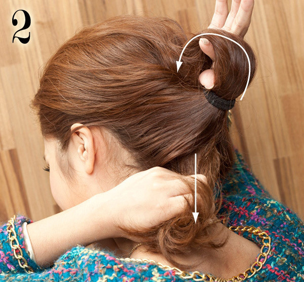 Đem phần đuôi ngựa luồn qua khoảng trống vừa được tách ra. Kéo tóc che lấp dây buộc.